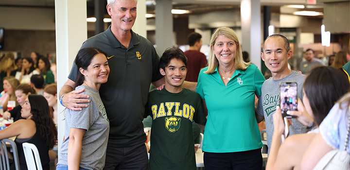 President Livingstone and Brad Livingstone standing with an incoming student and his parents. 