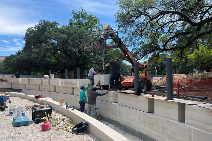 Workers install limestone stones for the Memorial to the Enslaved 