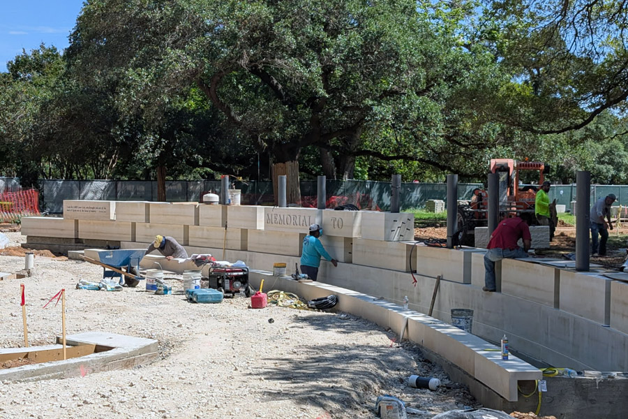Workers place stones at the Memorial to the Enslaved Memorial