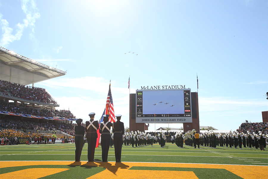 Soldiers with an American flag at McLane stadium